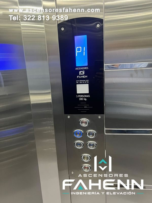 Mando interior de ascensor con display LED azul en P1, pulsadores cromados para dos niveles, apertura, cierre, alarma, comunicación y detención con lectura directa.