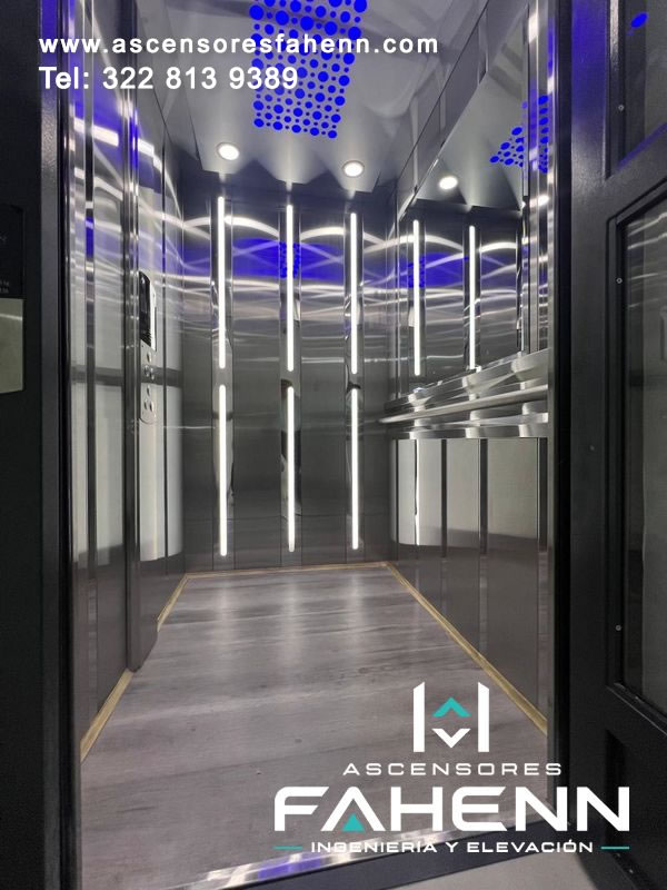 Interior de ascensor de lujo con iluminación LED vertical, paredes reflectivas, motivos azules superiores y piso de apariencia amaderada.