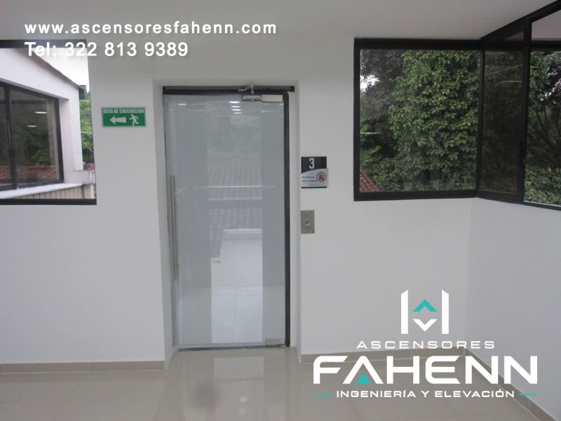 Puerta para ascensor en vidrio esmerilado con tirador, cierrapuertas, pulsador e indicador del tercer piso.