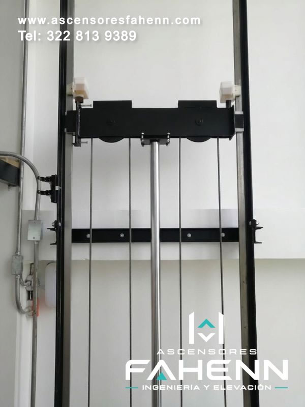 Componentes de ascensor con guías, poleas, cables y cilindro central integrados para proporcionar desplazamiento uniforme, estabilidad mecánica y control seguro diario.