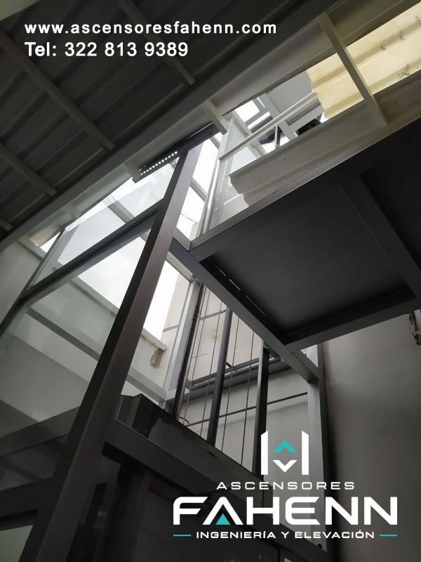 Estructura de acero para ascensor con plataforma, soportes y guías verticales diseñada para distribuir cargas y proporcionar elevación estable dentro del edificio.