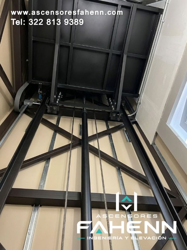 Plataforma portante de ascensor con pistón hidráulico, cables y refuerzos estructurales que aportan estabilidad, resistencia y elevación segura en cada recorrido.
