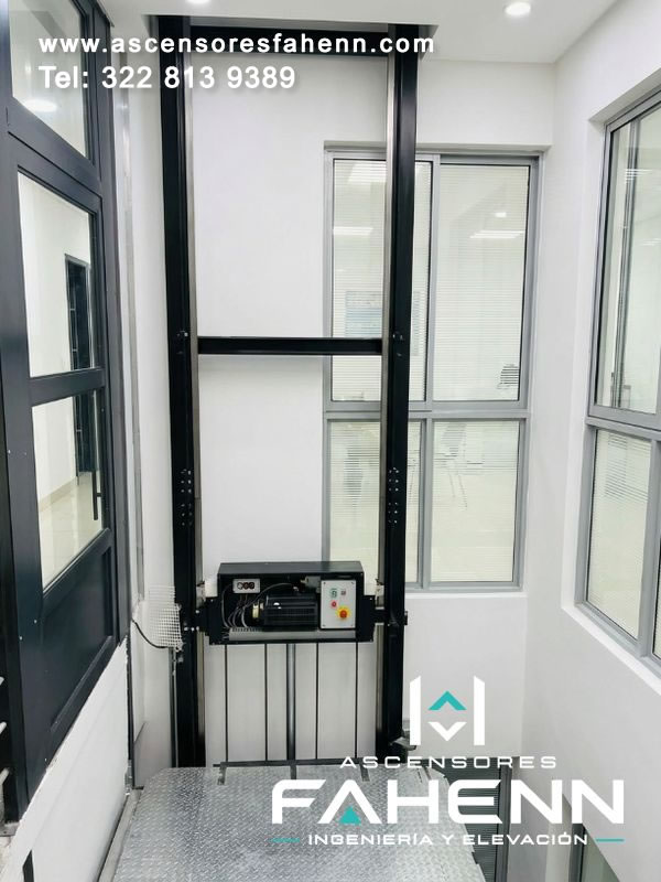 Plataforma elevadora de personas con motor, tablero de control y piso antideslizante que ofrece acceso vertical cómodo, estable, seguro y fiable en espacios interiores.