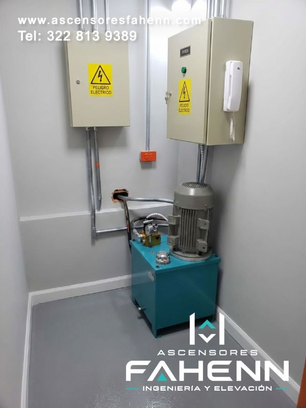 Sala técnica de ascensor hidráulico con motor, depósito y doble tablero eléctrico distribuido para facilitar control y mantenimiento en Bogotá, Colombia.