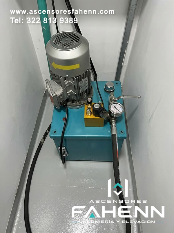 Componentes eléctricos e hidráulicos para ascensor con motor, tanque, manómetro y conexiones organizadas para una operación estable en Bogotá.