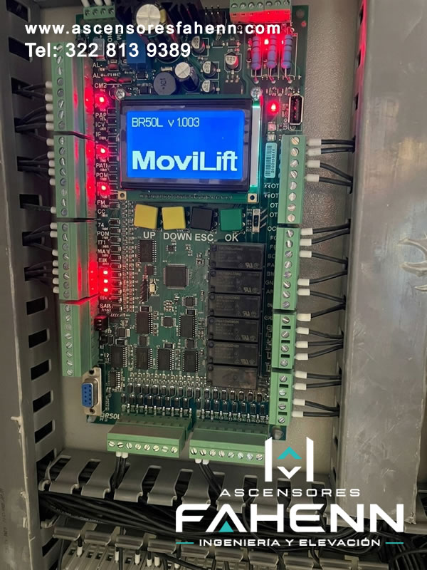 Tarjeta controladora para ascensor con pantalla, relés, entradas y salidas electrónicas que permiten gestionar parámetros y verificar señales de operación.