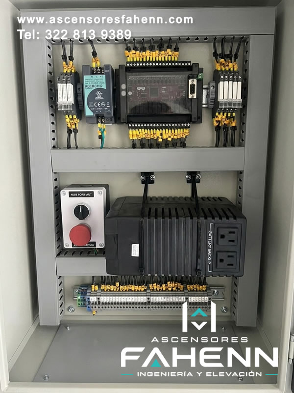 Tablero de control para ascensor con controlador, fuente, relés, borneras y respaldo de batería organizados para ofrecer continuidad y diagnóstico preciso.